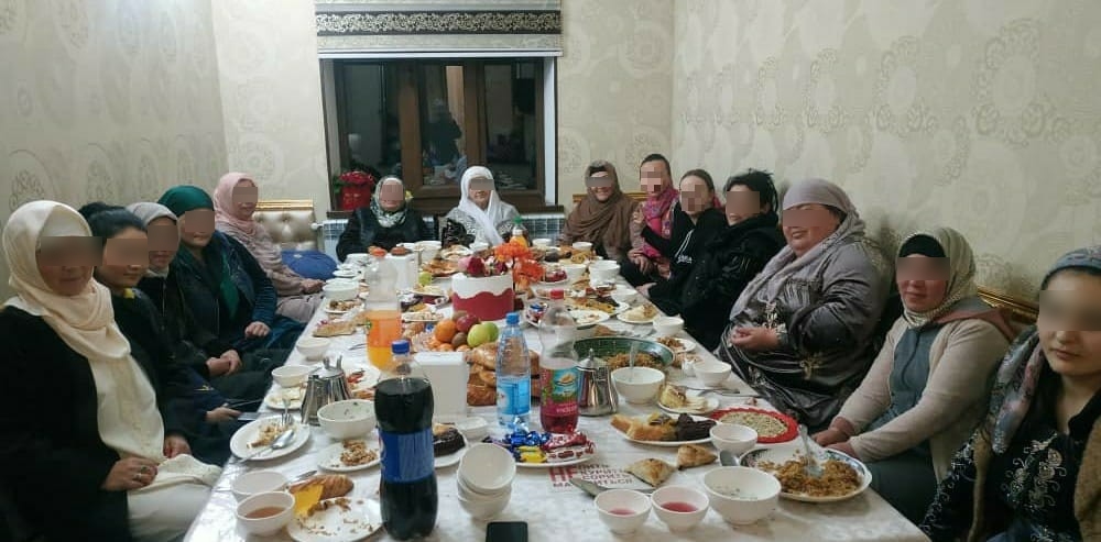 Women gathered around a table sharing a meal during an outreach visit